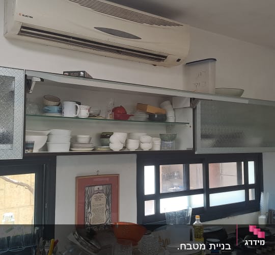 מטבח עם ארונות פתוחים וכלים על השיש